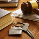 Property law concept. Key from real estate and gavel.